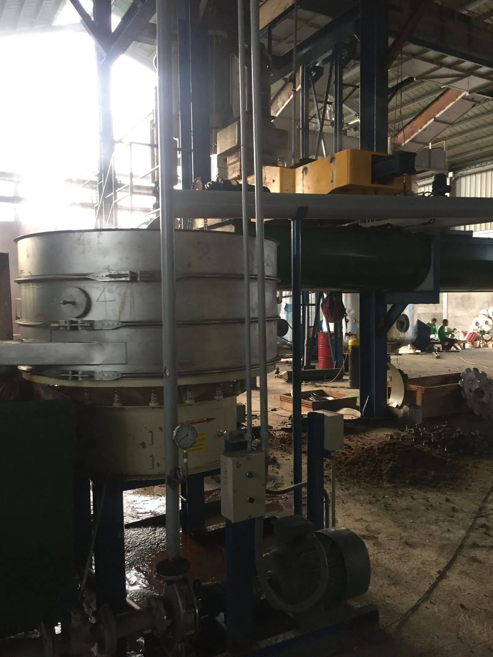 Vibrating screen installed below a process vessel