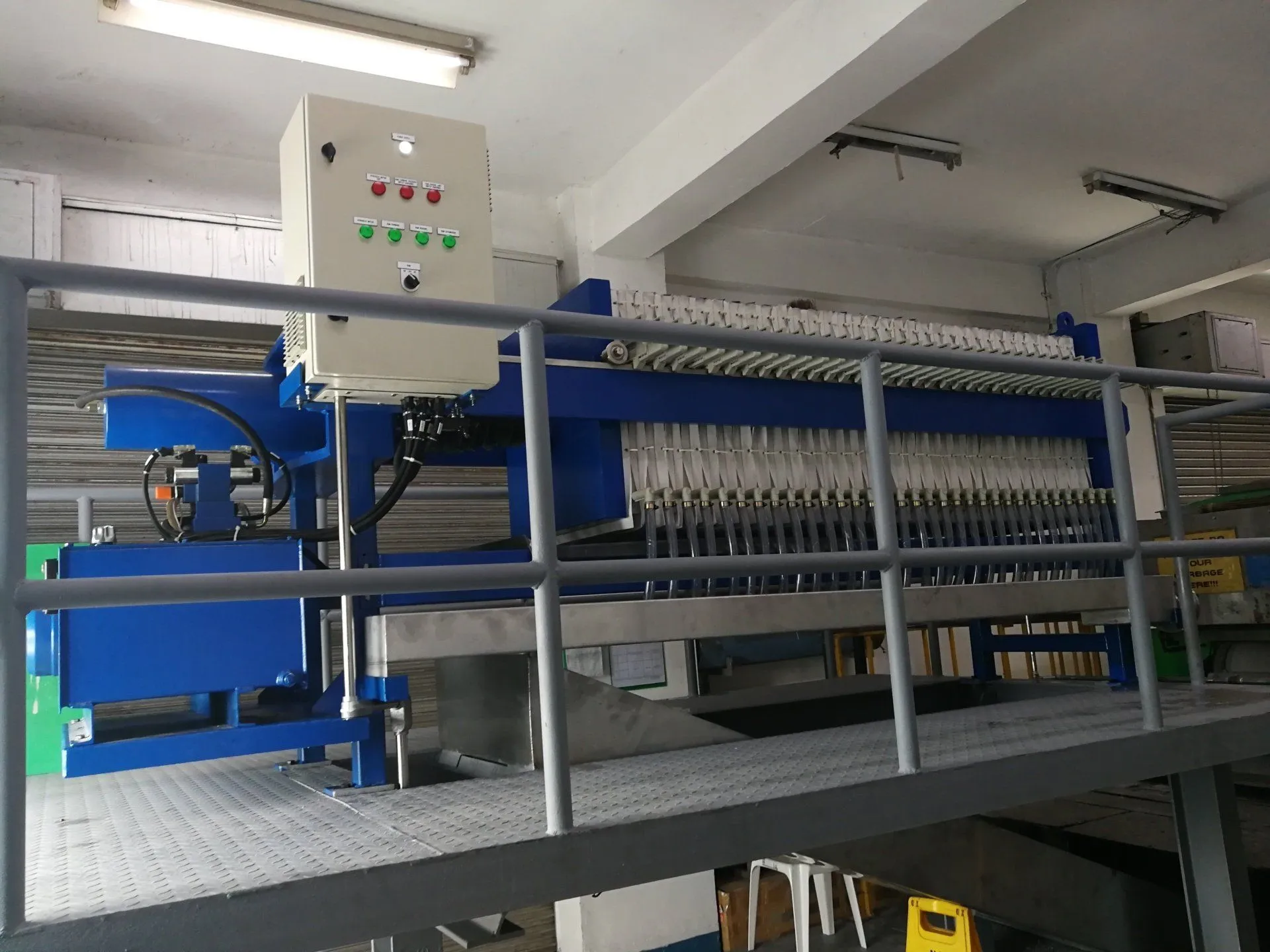 Filter press with automatic plate shifter inside a plant