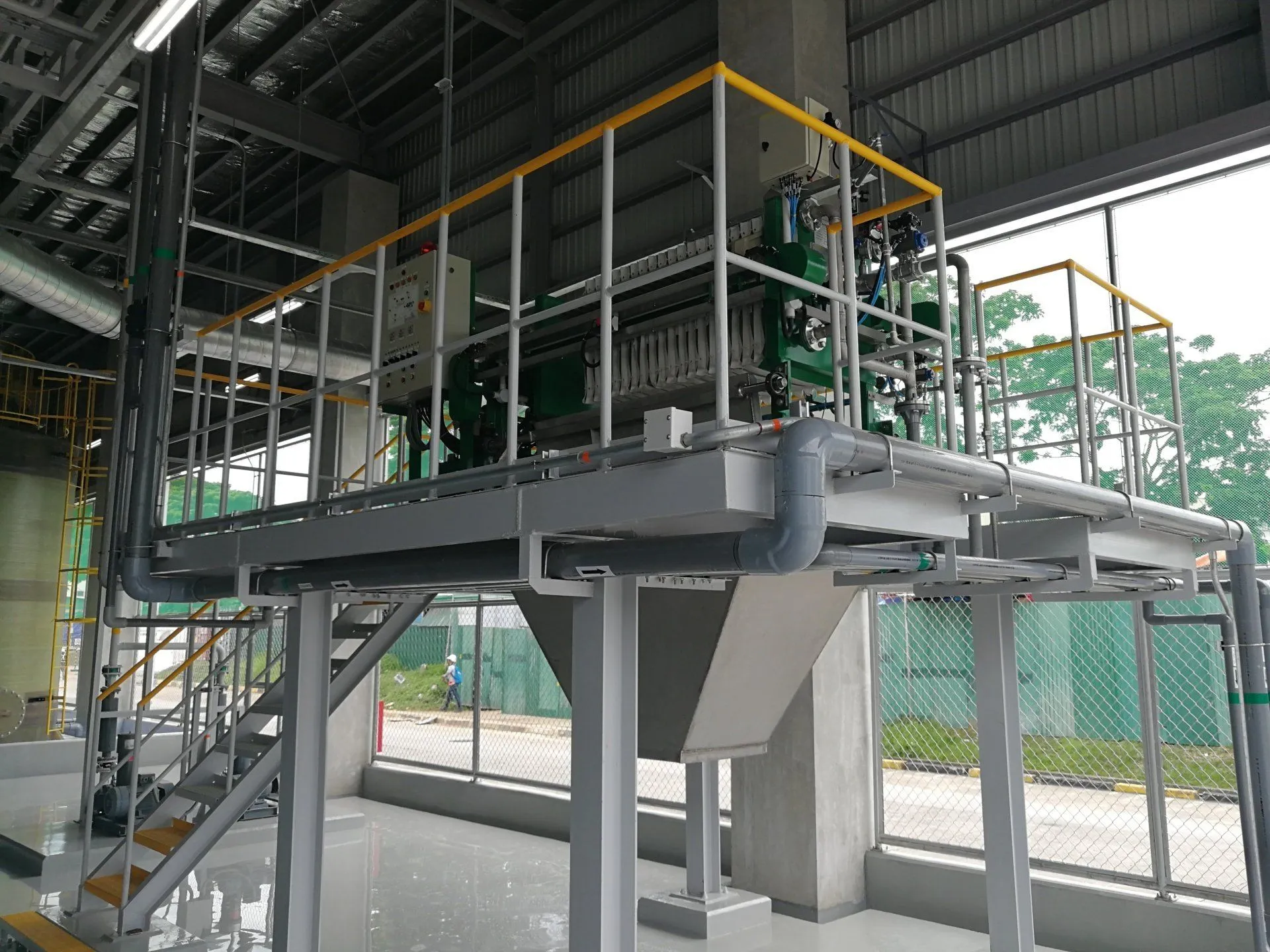 Filter press on an elevated steel platform with cake chute